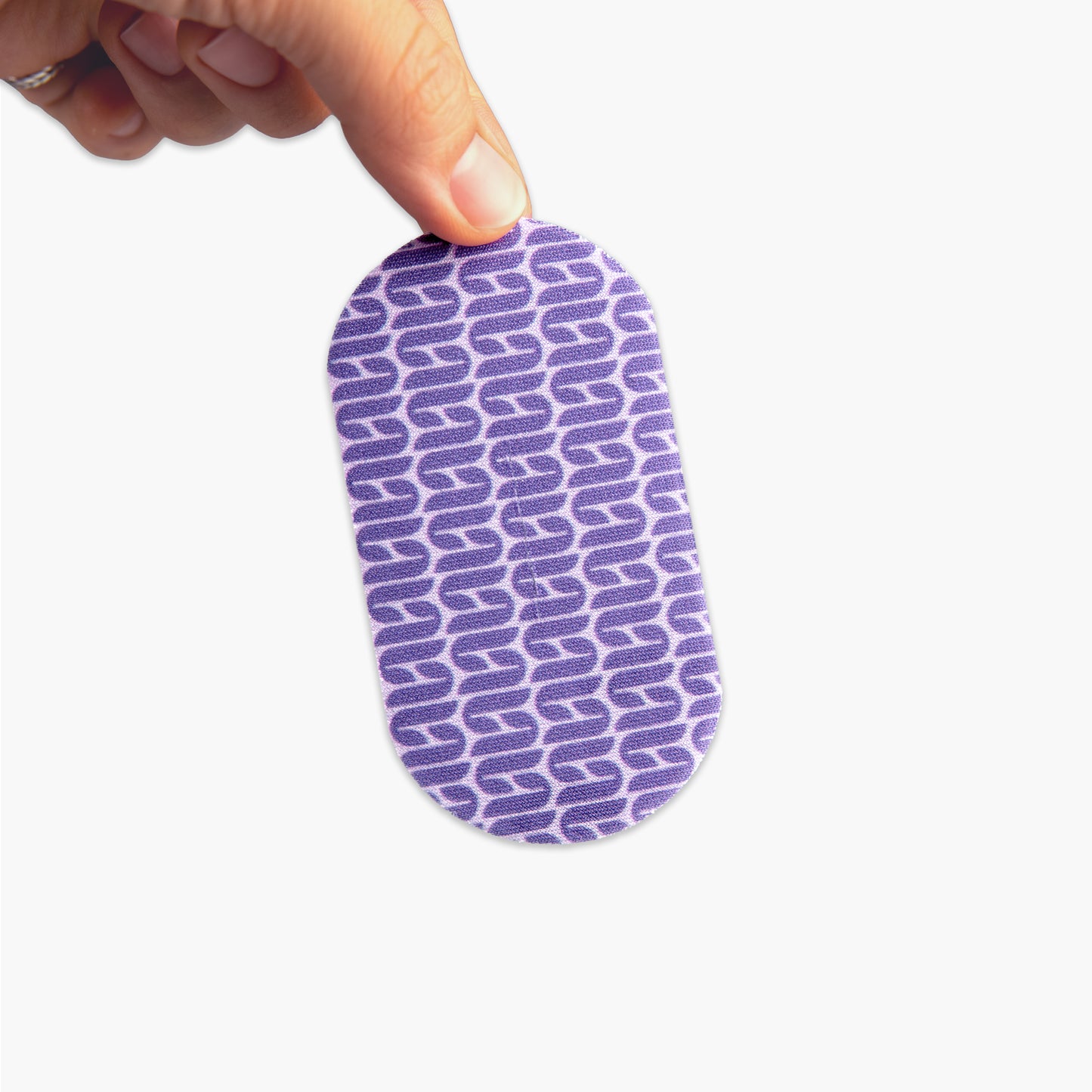 Hand holding a purple and white patterned mouth tape strip against a white background