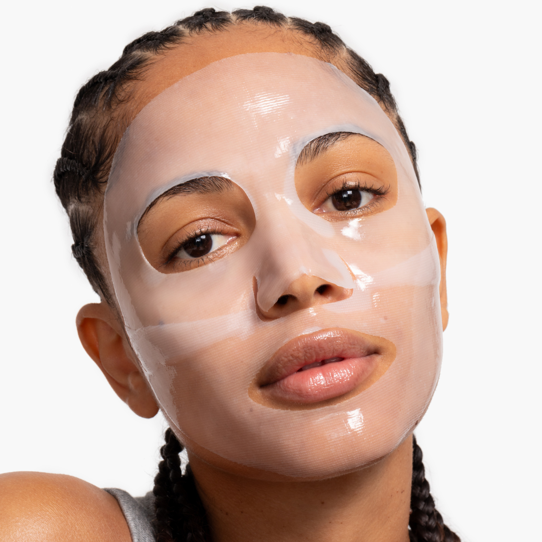 Woman wearing a beige facial mask on a white background