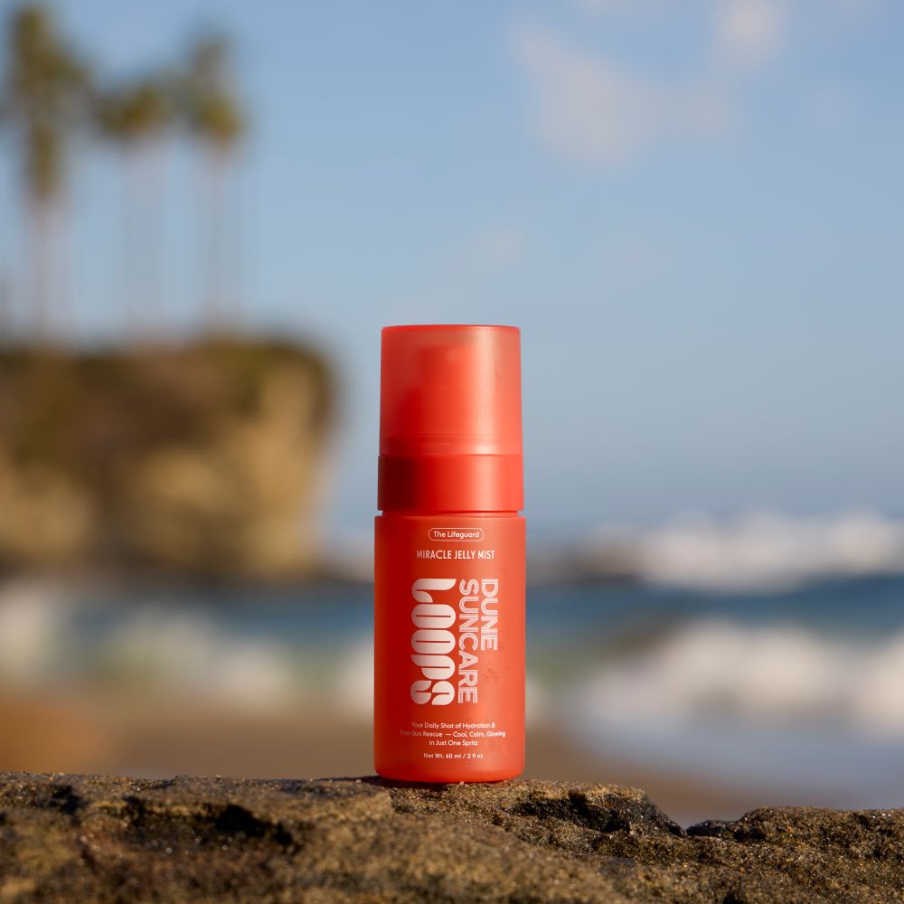 A closeup image of LOOPS x Dune Skincare Jelly Mist with an ocean faded in the background