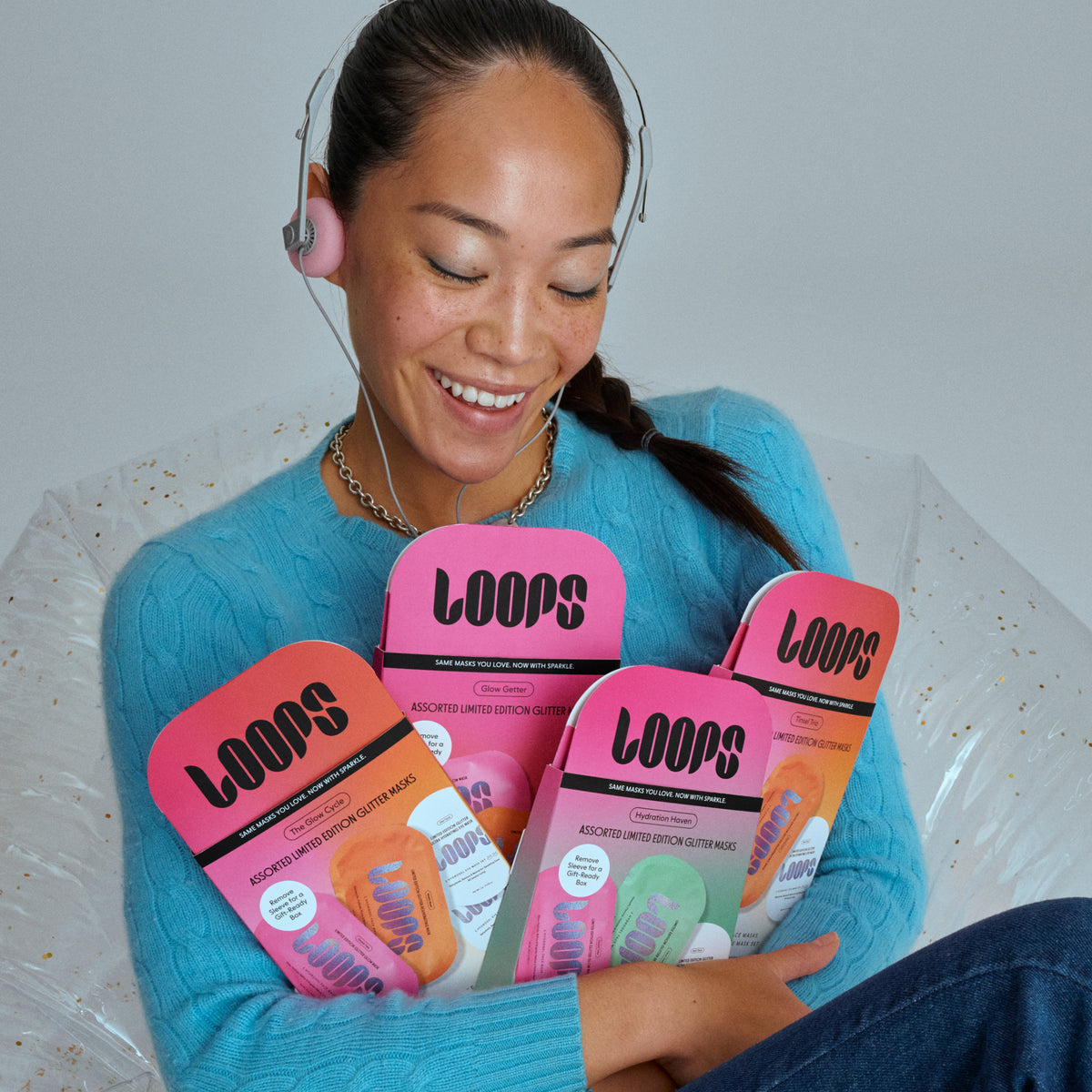 Image of smiling model holding 4 holiday gift sets