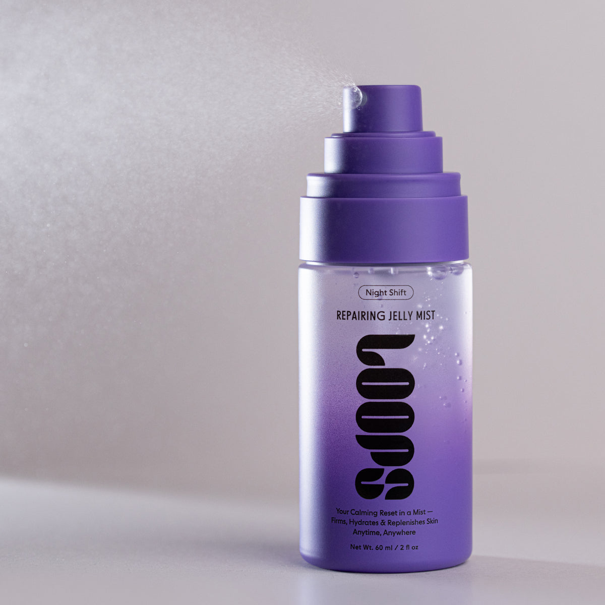 A bottle of Loops Night Shift Repairing Jelly Mist with a purple pump dispenser and a clear body showing a purple gradient liquid inside, set against a neutral gray background.