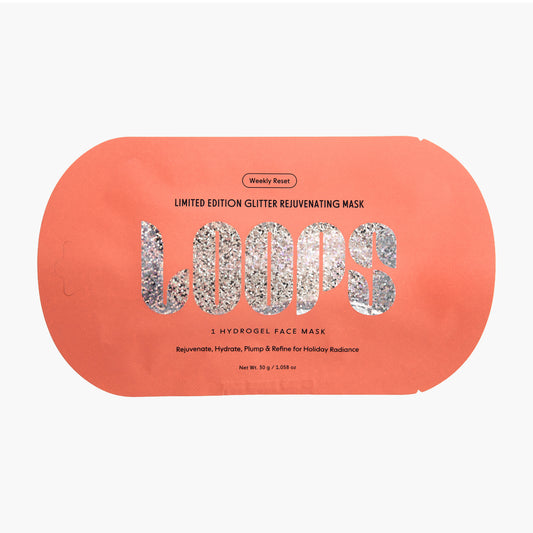 A peach-colored weekly reset face mask packet featuring a glittery silver 'LOOPS' logo and text for a limited edition glitter rejuvenating mask.